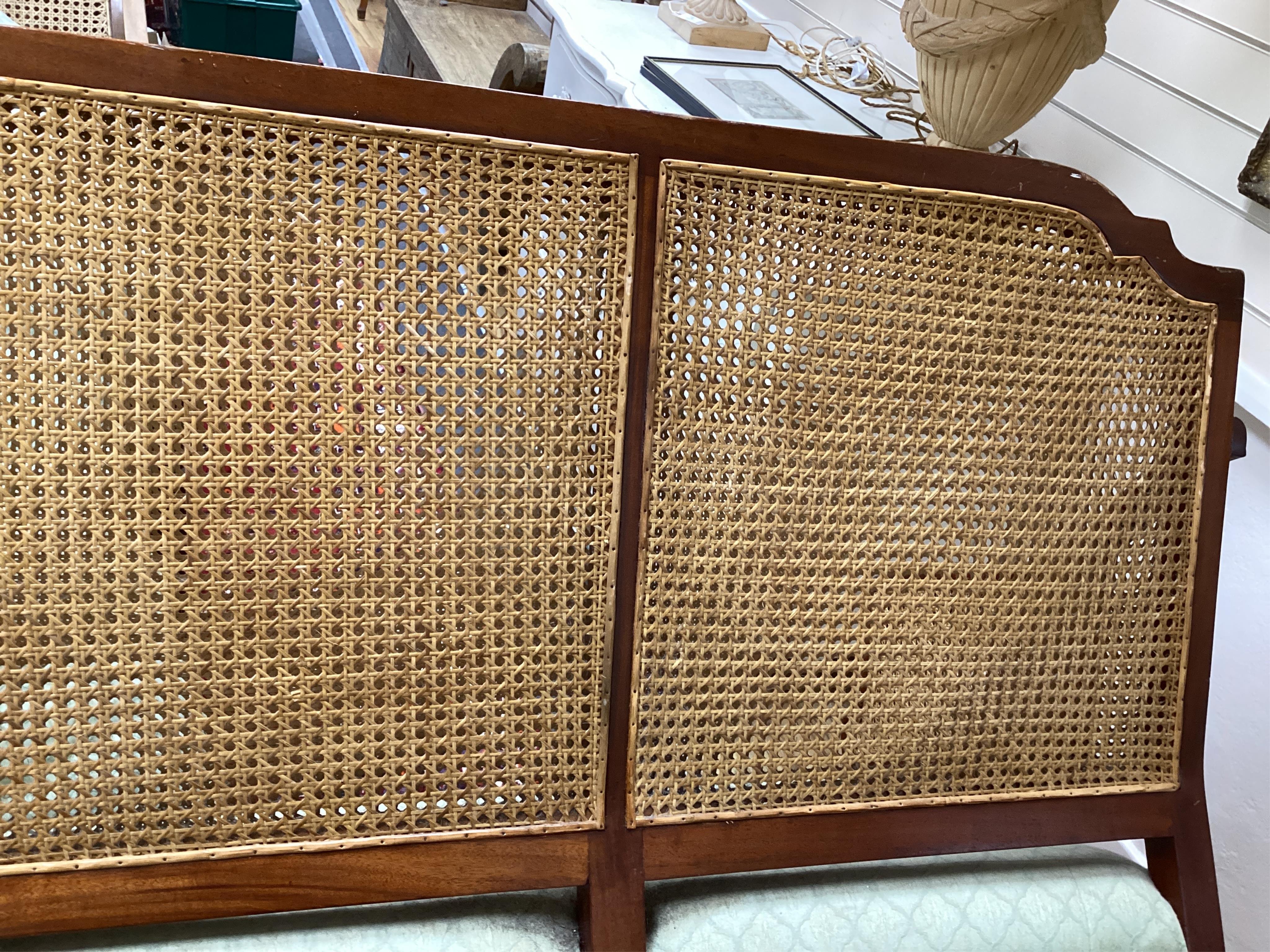 A mahogany double caned bergere settee with loose cushion seat and back, width 178cm, depth 78cm, height 87cm